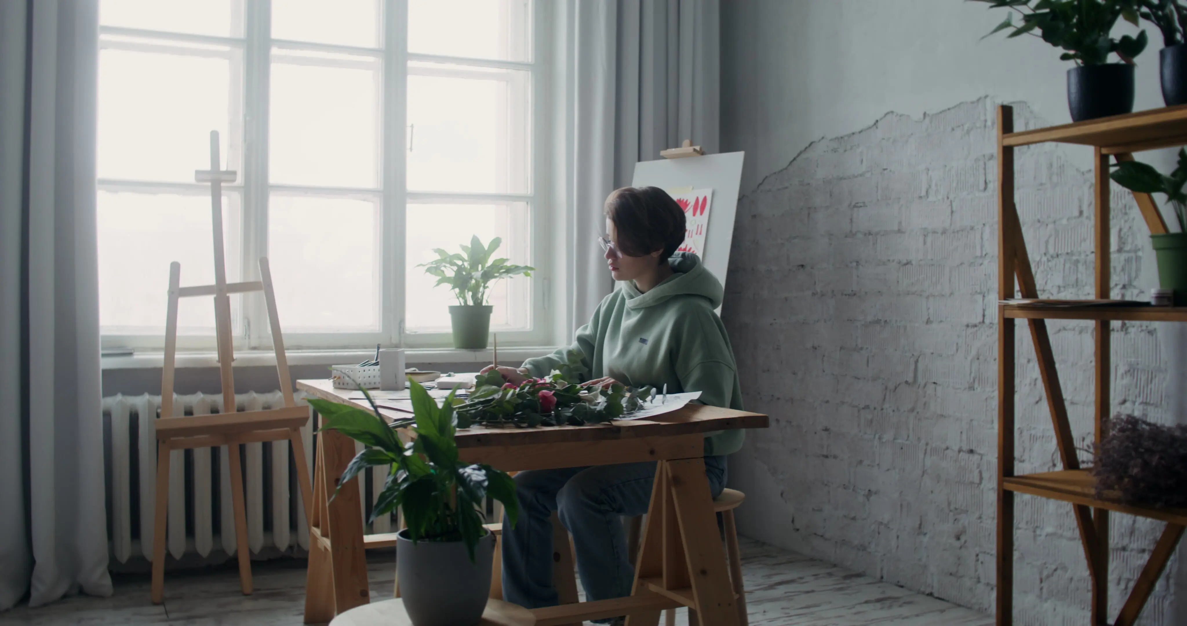 Künstlerin malt mit Aquarellfarben in einer Werkstatt.